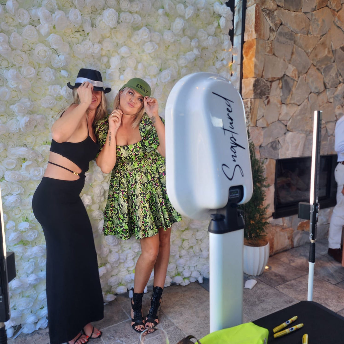 Selfie time at a photo booth in front of a floral back drop